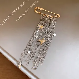 Close-up of star tassel brooch with gold peace dove pendants on silver chains