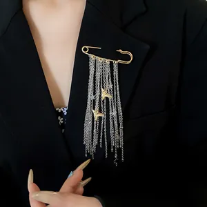 Detail shot of a silver chain tassel brooch with gold stars on a black blazer