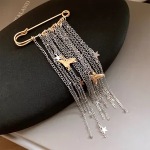 Close-up of star and peace dove tassel chain brooch with gold and silver accents
