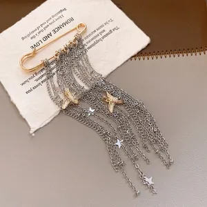 Close-up of fashion star tassel chain brooch with peace dove pendants on prop card