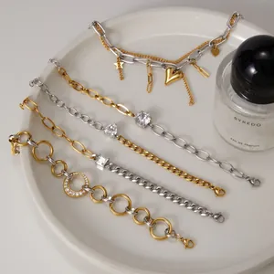 Détail de divers bracelets en acier inoxydable bicolore or et argent avec zircons.