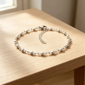 Dettaglio macro di un bracciale a sfere in acciaio inossidabile su un tavolo di legno