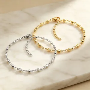 Dettaglio ravvicinato di bracciali a catena con sfere in acciaio inossidabile oro e argento