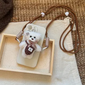 Detail view of plush bear phone pendant with adjustable brown crossbody nylon strap