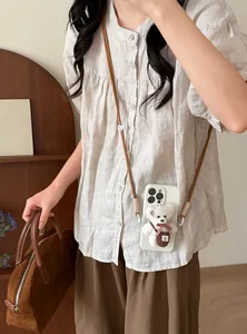Detailed view of plush bear pendant and double nylon rope lanyard on white phone case
