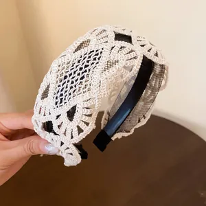 Detail showing the intricate hollow lace crochet pattern of the vintage wide headband