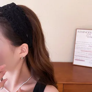 Close-up detail of a vintage black lace wide headband worn by a model in a warm room