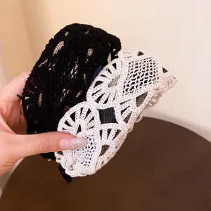 Close-up detail of French vintage wide lace headbands in black and beige crochet colors.