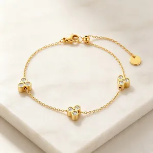 Detailansicht der funkelnden Strasssteine im goldenen Blumen-Armbanddesign.