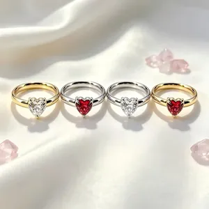 Élégante rangée de bagues en forme de cœur en or et argent avec zircons rouges et blancs.