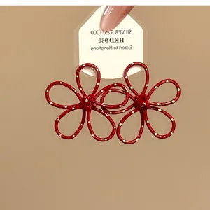 Detailansicht der süßen roten Polka-Dot-Blumenohrringe mit hohlem Metallblütenblatt-Design