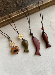 Dettaglio di quattro collane artigianali con ciondoli in legno a forma di pesce e gatto.