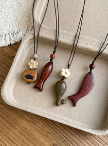 Primo piano di ciondoli in legno a forma di pesce e gatto in stile neo-cinese.