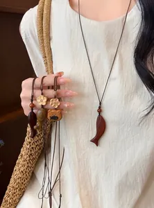 Dettaglio di una collana artigianale con ciondolo a forma di pesce in legno per donna