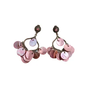 Elegant pink circular shell tassel earrings with vintage metallic frame and gem.