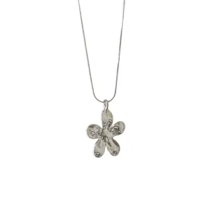 Collier avec pendentif fleur argenté minimaliste présentant une texture martelée polie unique