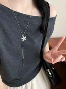 Vue détaillée d'un collier pendentif fleur argenté sur un mannequin au style chic