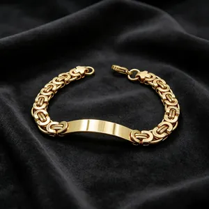 Close-up detail of a gold Byzantine chain bracelet featuring a polished curved metal ID plate