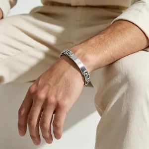 Close-up view of a minimalist men's titanium steel Byzantine chain bracelet on a wrist.