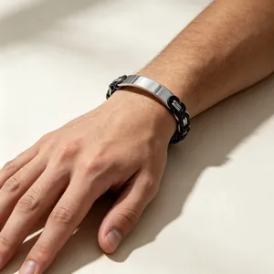 Close-up of a men's Byzantine chain bracelet with a polished metal ID plate on a wrist.