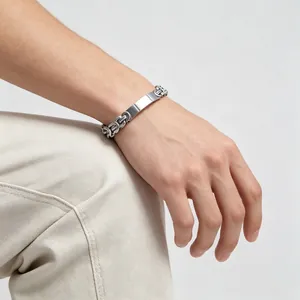 Close-up of a silver Byzantine chain bracelet with a blank engravable plate on wrist