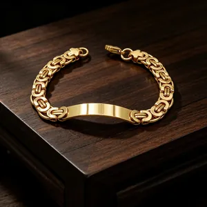 Close-up of a gold titanium steel Byzantine chain bracelet with a blank curved plate