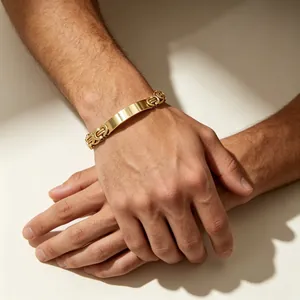 Close-up of a gold Byzantine chain bracelet with a smooth curved plate on a male wrist