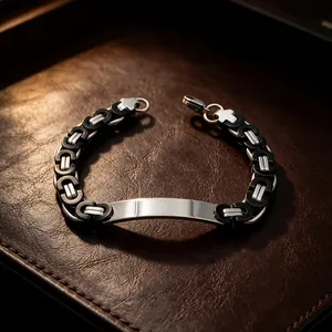 Detailed view of a men's Byzantine chain bracelet with a polished engravable plate