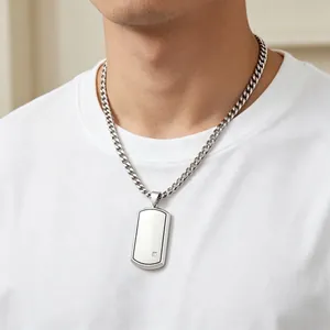 Close-up of a men's steel dog tag necklace with a small diamond on a Curb chain.