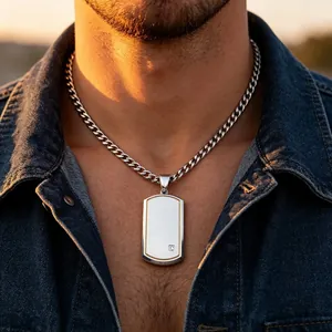 Detailed close-up of a men's silver dog tag pendant with gold trim worn by a male model.