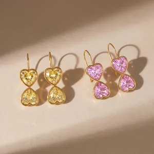 Detailed view of 18k gold plated stainless steel heart earrings with pink and yellow crystals