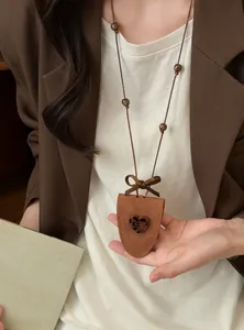 Elegante Lederbeutel-Pulloverkette mit Leoparden-Harzherz und Schleifendetail am Modell