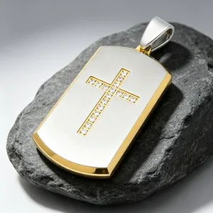 Detailed view of a gold and silver stainless steel cross dog tag pendant with crystals.