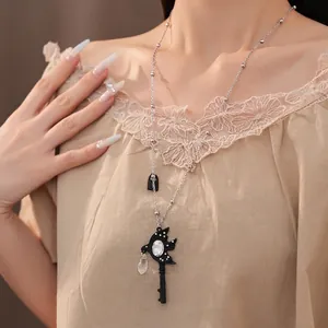 Elegant silver swallow key necklace featuring clear rhinestone waterdrop on female model