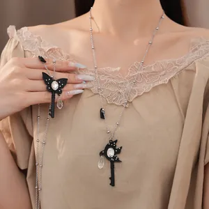 Detailed view of rhinestone butterfly and swallow key necklaces on a female model
