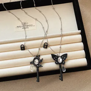 Macro view of butterfly and swallow key necklaces featuring teardrop glass crystals