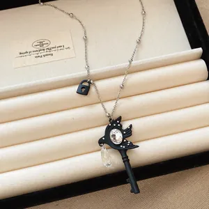 Detail view of a gothic swallow key necklace with sparkling rhinestones in a display box.