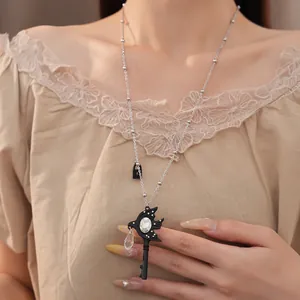 Close-up detail of swallow key necklace with water drop crystal pendant for women