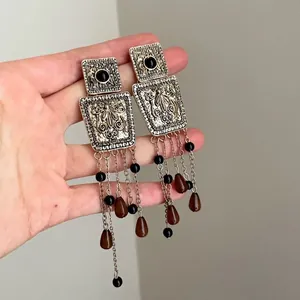 Detailed close-up view of vintage court-style square tassel earrings with golden texture