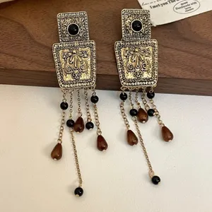 Detailed macro shot of vintage court style square drop earrings with beaded tassels