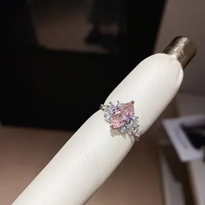 Detail view of a sparkling pink marquise-cut zircon open ring with clear side stones.
