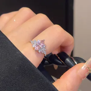 Close-up of a sparkling pink marquise zircon ring worn on a finger with luxury manicure.