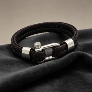 Gros plan d'un bracelet en cuir tressé marron foncé à double couche avec fermoir en fer à cheval.