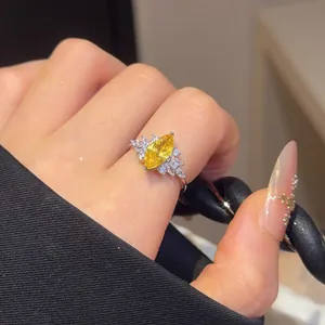 Close-up of sparkling yellow marquise-cut zircon ring with elegant side stone detailing