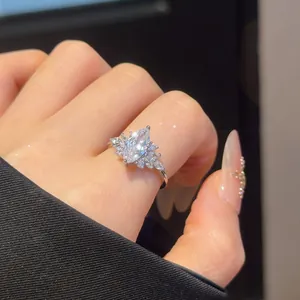 Close-up detail of a sparkling marquise-cut cubic zirconia silver ring on a woman's hand.