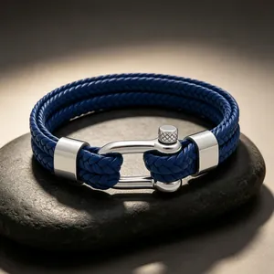 Détail macro du bracelet en cuir tressé bleu à double couche avec fermoir manille argent