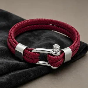 Gros plan d'un bracelet en cuir tressé bordeaux à deux rangs avec fermoir en argent.