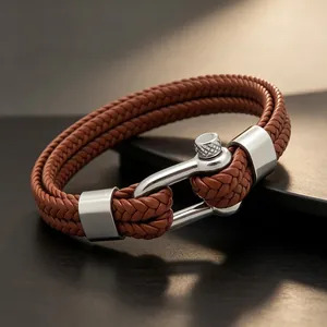 Gros plan d'un bracelet en cuir tressé marron à double rang avec boucle manille en acier