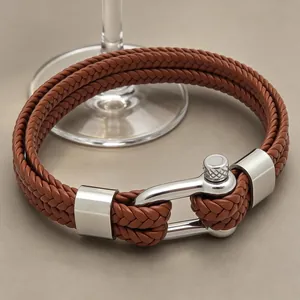 Détail d'un bracelet en cuir tressé marron à double épaisseur avec boucle en acier