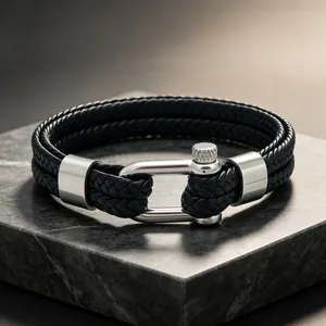 Gros plan d'un bracelet en cuir tressé avec fermoir à vis en acier inoxydable argenté.